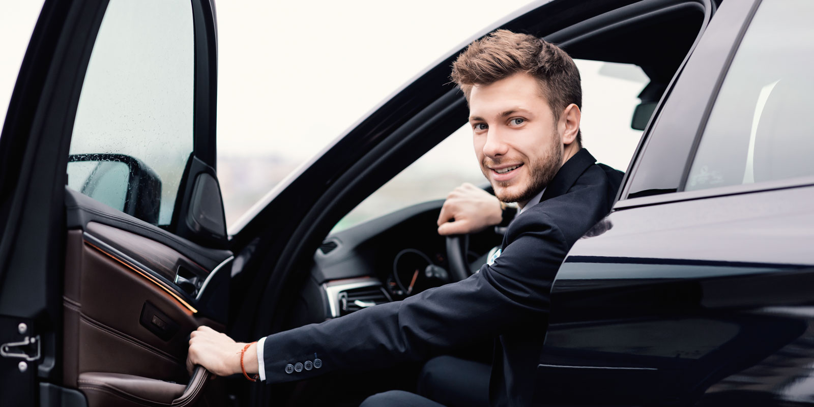DriveMe privéchauffeur staat klaar om in de auto van de klant naar de luchthaven te rijden