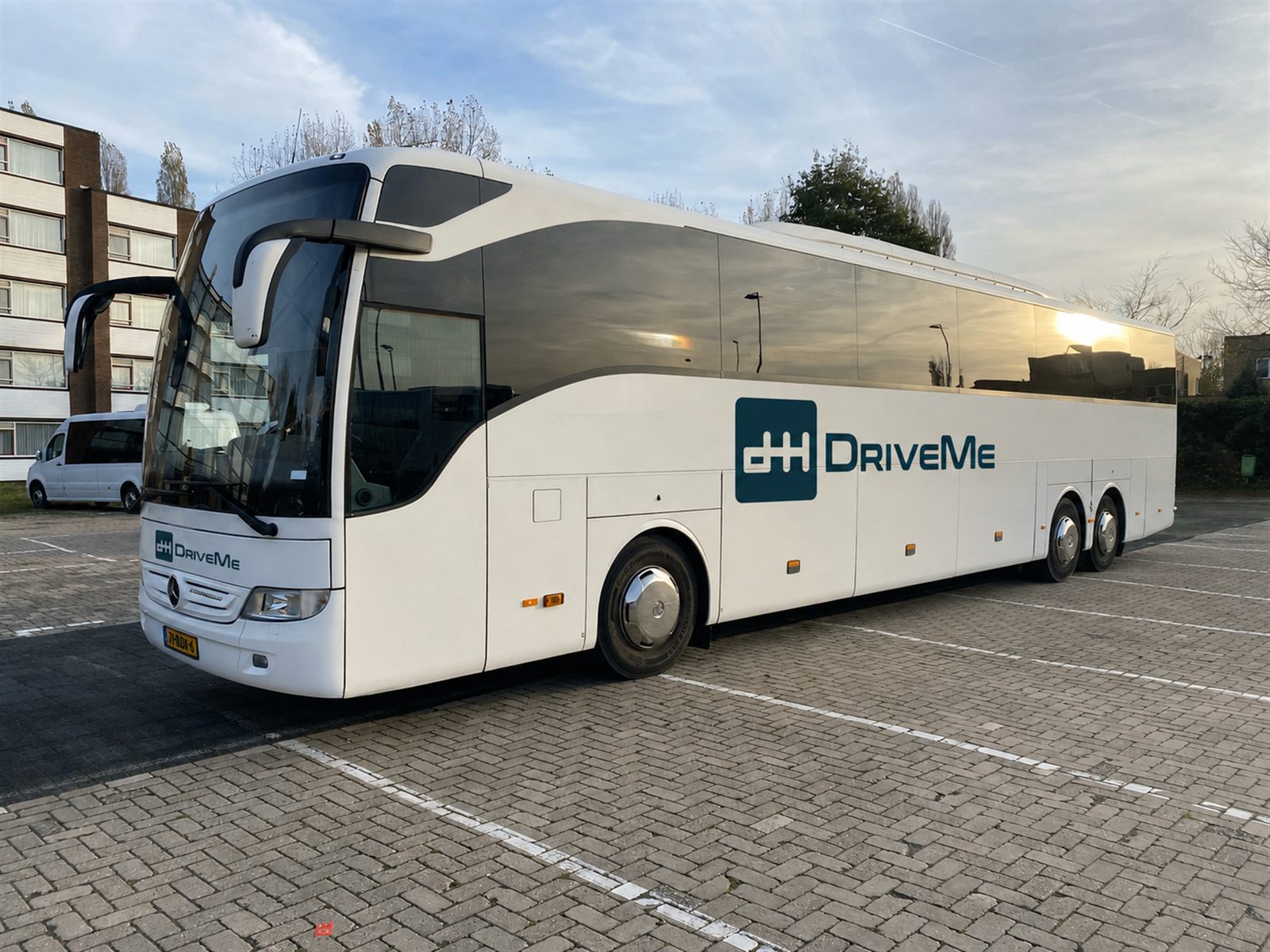 Witte DriveMe touringcar voor groepsvervoer bij teamuitjes met meer dan 27 personen